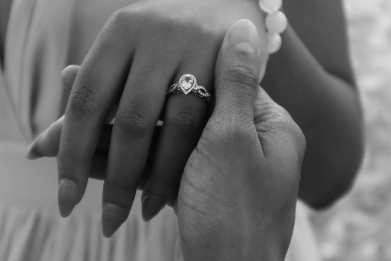 Black and white image of a bride wearing a pear shaped engagement ring