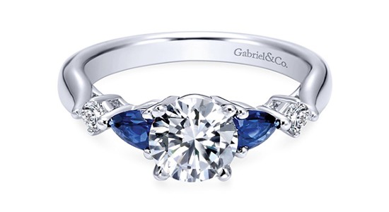 a silver, three stone ring with sapphire side stones by Gabriel & Co.