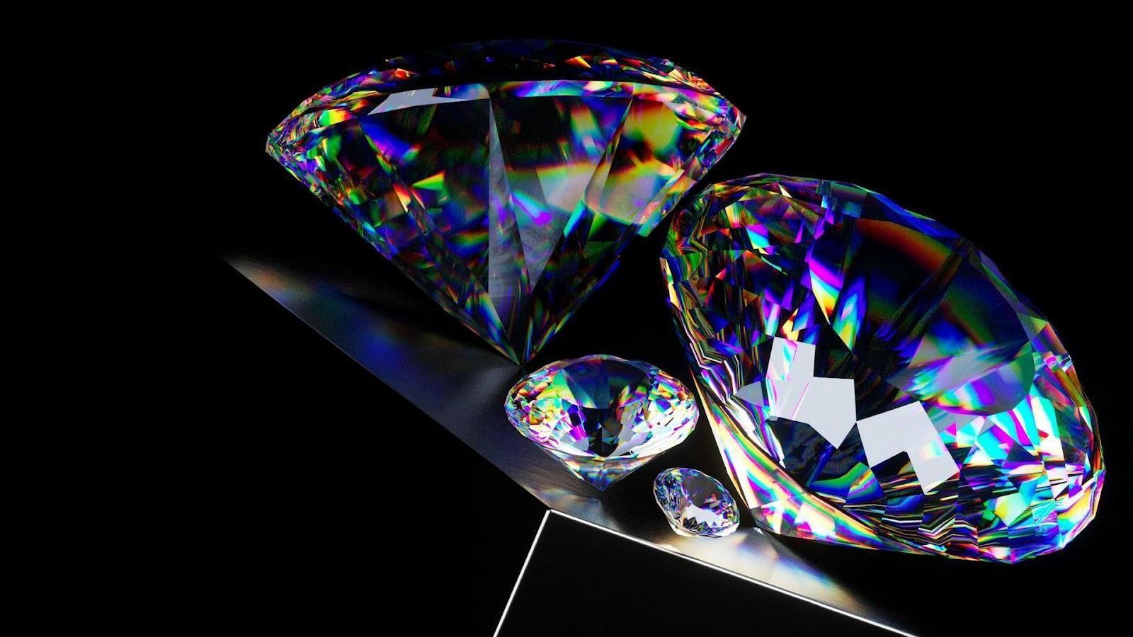 An angled view of four radiant round cut diamonds of different sizes reflecting a spectacular spectrum of color.