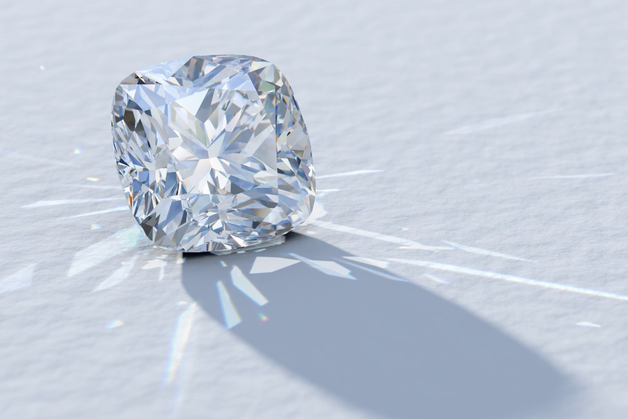 A close-up of a cushion cut diamond beautifully catching and reflecting light on a white backdrop.