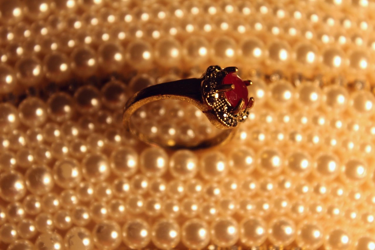 a ruby ring situated atop strings of pearls