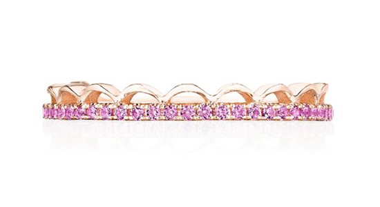 a wedding band featuring pink gemstones and scalloped details