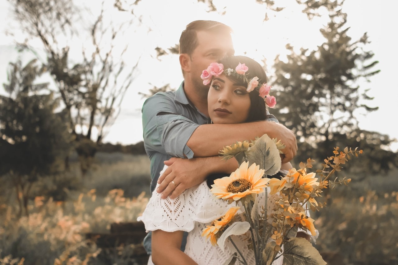 a man with his arm around a lady wearing a wedding band